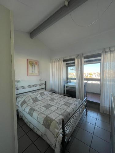 une chambre avec un grand lit et une fenêtre dans l'établissement LE SUN SET de la Coudalere, au Barcarès