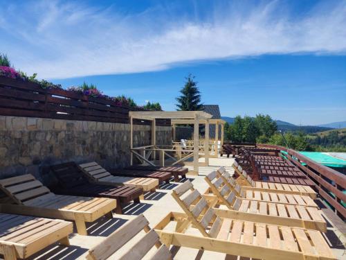 a group of wooden benches sitting next to a pool at Khatky Na Penkakh in Vorokhta