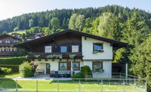 a house on a hill with trees in the background at Landhaus Gappmaier in Zell am See