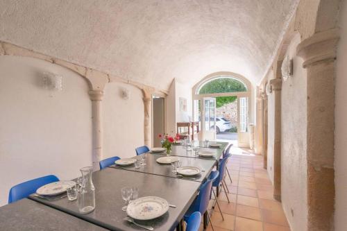 une salle à manger avec une grande table et des chaises bleues dans l'établissement CABANA & Le Gîte du Château - Proche Mâcon Nord, à Lugny