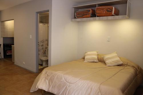 El Racimo, dpto en Ciudad de Mendoza في ميندوزا: غرفة نوم عليها سرير ووسادتين