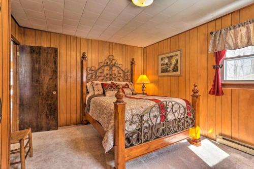 1 dormitorio con 1 cama en una habitación con paredes de madera en Peaceful Pocono Lakefront, beach, pools, firepit, pets, en Arrowhead Lake