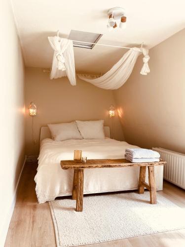 - une chambre avec un lit et une table en bois dans l'établissement Casita aan Zee 2 slaapkamers 2 badkamers 3 min van zee, à Zandvoort