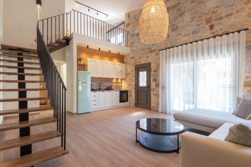 - un salon avec un escalier, un canapé et une table dans l'établissement Ntinas Filoxenia Hotel & Spa, à Skala Potamias