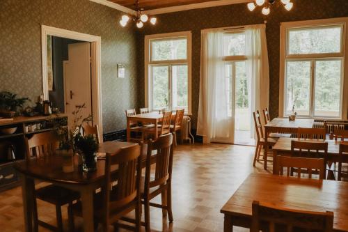 a dining room with tables and chairs and windows at Turistgården Särna in Särna