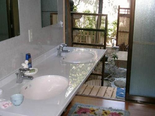 a bathroom counter with two sinks and a mirror at Daiya Ryokan in Kyoto