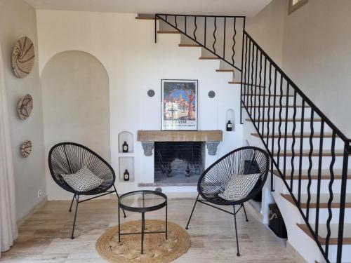a living room with two chairs and a fireplace at Les Hauts de la Riviera in Cabris