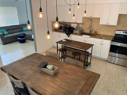 a kitchen with a wooden table and a dining room at Stayover In Miami Home 2BR - 1BTH - free parking in Miami