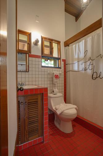 a bathroom with a toilet and a sink at Apartotel Girasol in Jacó