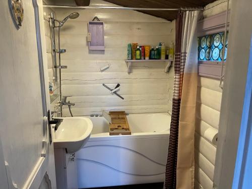een badkamer met een bad, een wastafel en een bad bij Norsk bjælkehytte med fibernet in Slagelse