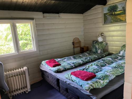 2 camas en una habitación con ventana en Norsk bjælkehytte med fibernet, en Slagelse
