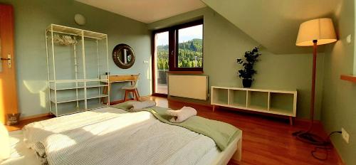 a bedroom with a large bed and a large window at To Tu Dom in Brenna