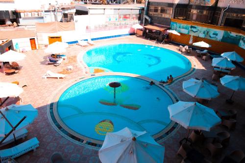 an overhead view of a large swimming pool with umbrellas at Aracan Portsaid in Port Said