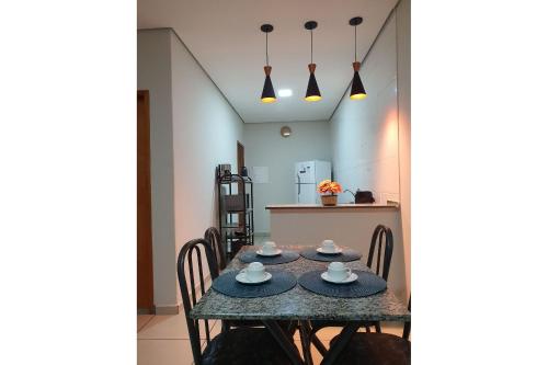 uma mesa de jantar com cadeiras e uma cozinha em Achei Casa , aluguel por temporada em Porto Velho