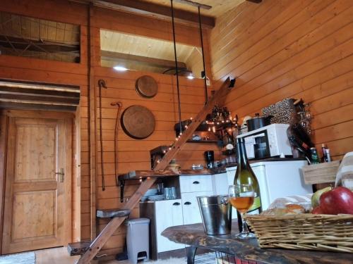 - une cuisine avec des murs en bois et une table avec une bouteille de vin dans l'établissement Το σπιτάκι του Σπύρου, à Oinokhórion