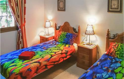 1 dormitorio con 2 camas con lámparas y sábanas coloridas en Nice Home In Rojales With House Sea View, en Rojales