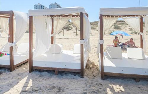 two beds on the beach with two people sitting in them at Cozy Home In Rojales With Sauna in Rojales