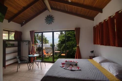 a bedroom with a bed and a view of a patio at Apartotel Girasol in Jacó