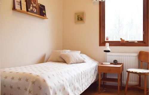 a bedroom with a bed and a table and a window at 2 Bedroom Lovely Home In Läckeby in Ugglerum