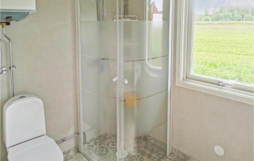 a shower in a bathroom with a toilet and a window at 2 Bedroom Lovely Home In Läckeby in Ugglerum