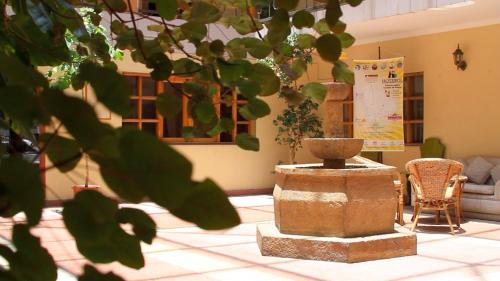 a room with a fountain in the middle of a room at Hotel Cima Argentum in Potosí