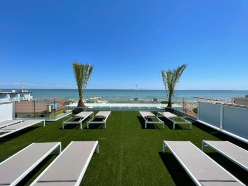a patio with benches and the ocean in the background at MAR60 Apartments in Caorle
