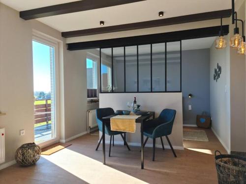 a dining room with a table and chairs at Stylische Wohnung mit Weitblick und großem Balkon in Karolinenkoog
