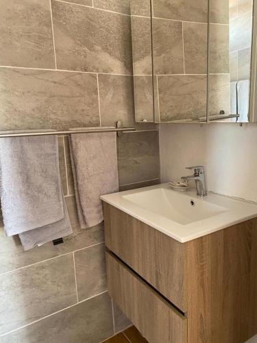 a bathroom with a sink and a mirror and towels at Apartamento Santos-Meerblick-Olhao-Algarve in Olhão