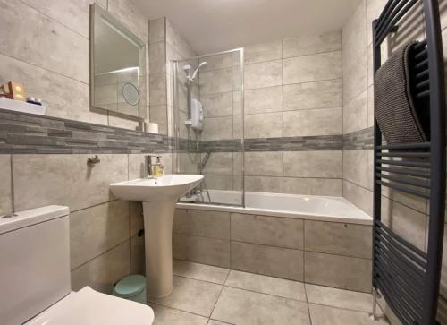 y baño con lavabo, bañera y aseo. en Sunningdale Lodge,St Mellion,Cornwall-FreeGolf&Spa, en St Mellion