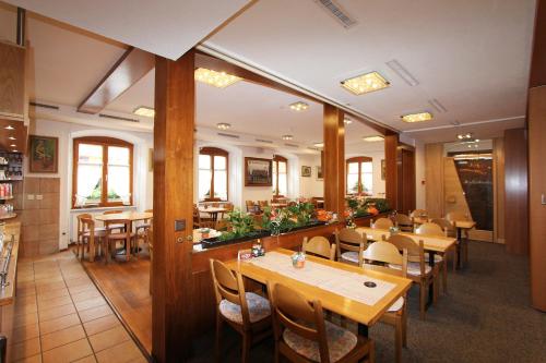 un restaurante con mesas y sillas de madera y ventanas en Gasthof Adler, en Frick
