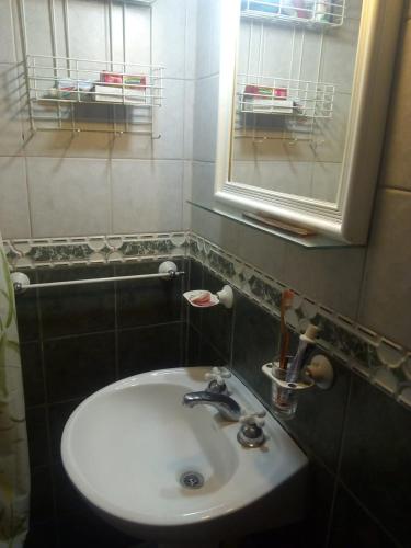 a bathroom with a white sink and a mirror at Dormitorio Privado in La Cieneguita