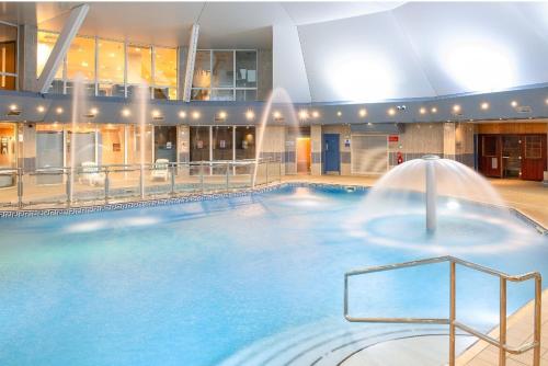 a large pool with a fountain in a building at Sunningdale Lodge,St Mellion,Cornwall-FreeGolf&Spa in St. Mellion