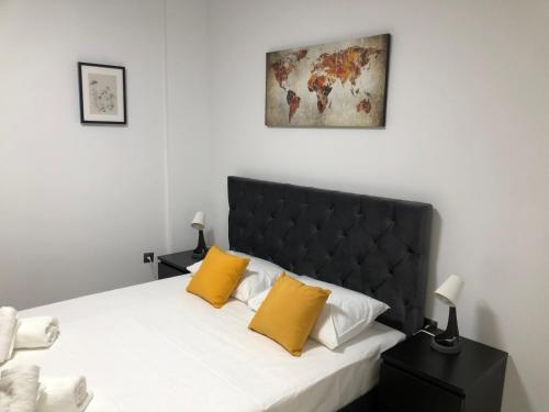 a bedroom with a bed with two yellow pillows at Our little 1 in Athens