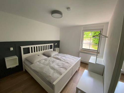 a bedroom with a white bed and a window at Bergschlösschen Edersee in Waldeck