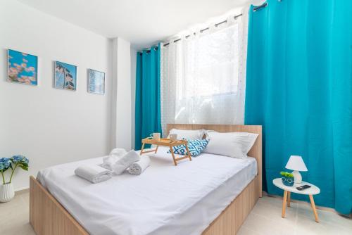 a bedroom with a large bed with blue curtains at Brand New Studio near Downtown in Heraklio