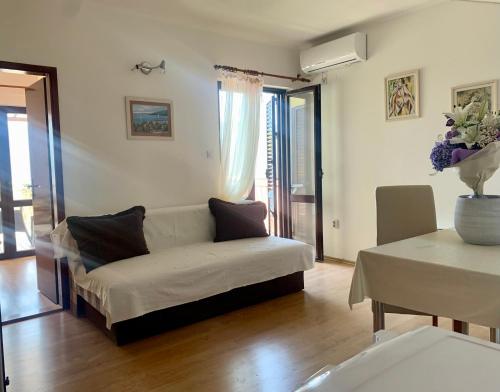 ein Wohnzimmer mit einem Sofa und einem Tisch in der Unterkunft Apartments Herceg Novi in Herceg-Novi