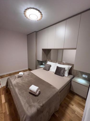 a bedroom with a large bed with two towels on it at Lilly LuX in Bijeljina