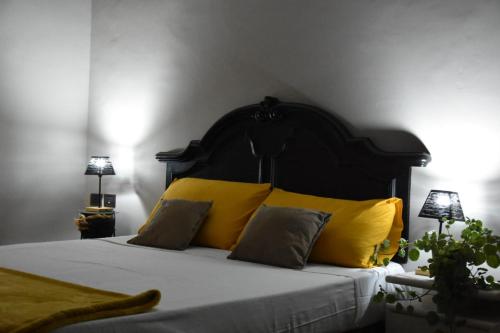 - une chambre avec un lit et des oreillers jaunes dans l'établissement Terme e relax nella campagna viterbese, à Viterbe