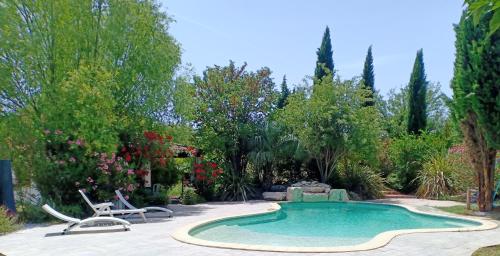 a swimming pool in a garden with chairs and trees at Instant Parfait Chambre privée et piscine in Monteux