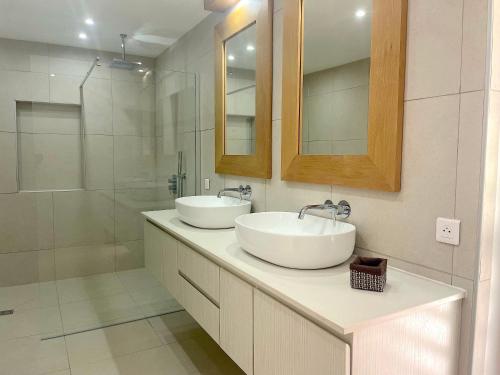 La salle de bains est pourvue de 2 lavabos et d'une douche. dans l'établissement The View, à Bora Bora