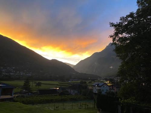 a sunset over a village in a valley with mountains at BluVilla in Malvaglia