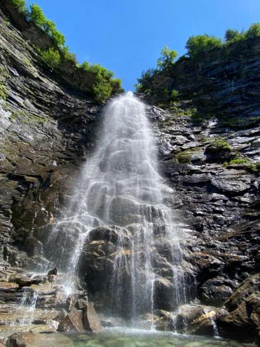 a waterfall on the side of a rocky mountain at BluVilla in Malvaglia