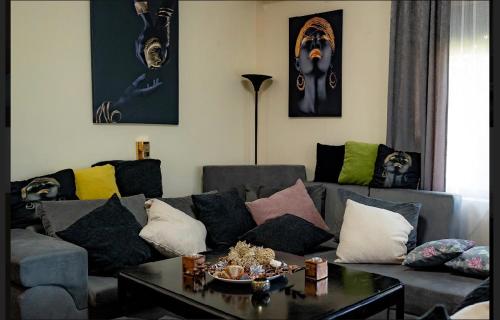 a living room with a couch with pillows and a table at Sunshine villa Dzhigurovo in Sandanski