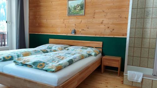 1 dormitorio con 1 cama con pared de madera en Appartment Florian, en Sankt Leonhard im Pitztal