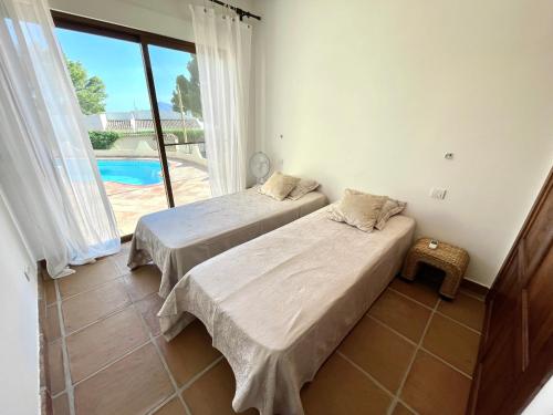 Кровать или кровати в номере Villa de estilo español con jardín y piscina