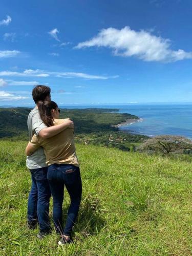 a man and a woman standing on top of a hill at Casa Melina Torio Cozy upscale 2bd jungle House in Torio