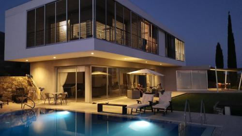 una casa con piscina frente a ella en Pluto luxury Villa, en Ora