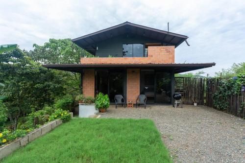 a brick house with a black roof and a yard at Casa Melina Torio Cozy upscale 2bd jungle House in Torio