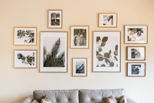 a row of framed photos on a wall above a couch at Bogoria Residence - LoftAffair Collection in Kraków