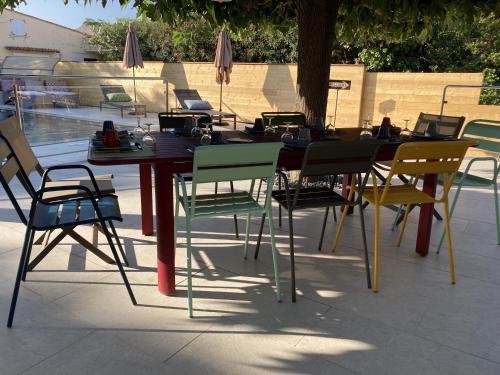 a table with colorful chairs and a table with at Casa Santa Giulia in Propriano